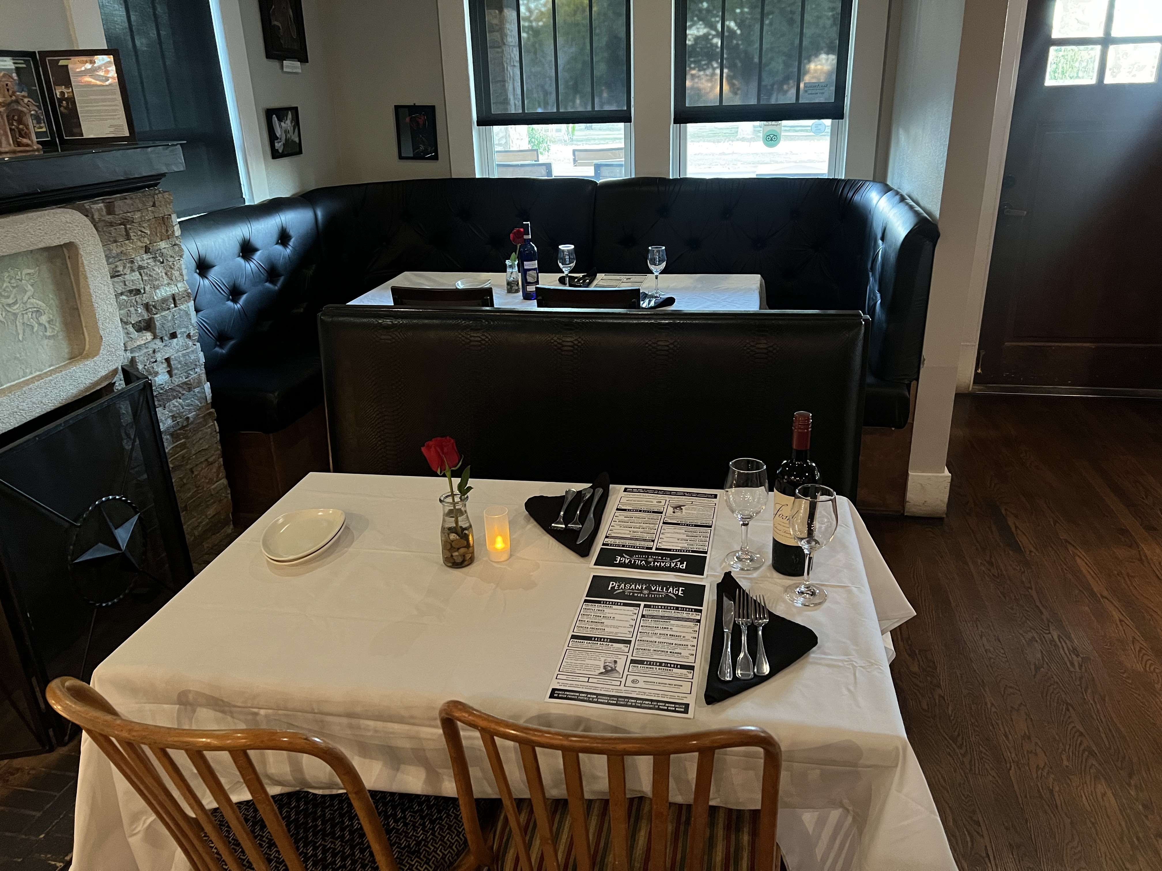 Elegant dining room at Peasant Village with white linen tables and warm lighting